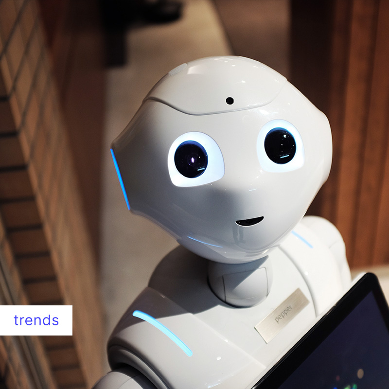 Vrolijk kijkende robot met gerichte blik, benadrukt de menselijke interactie met AI.
