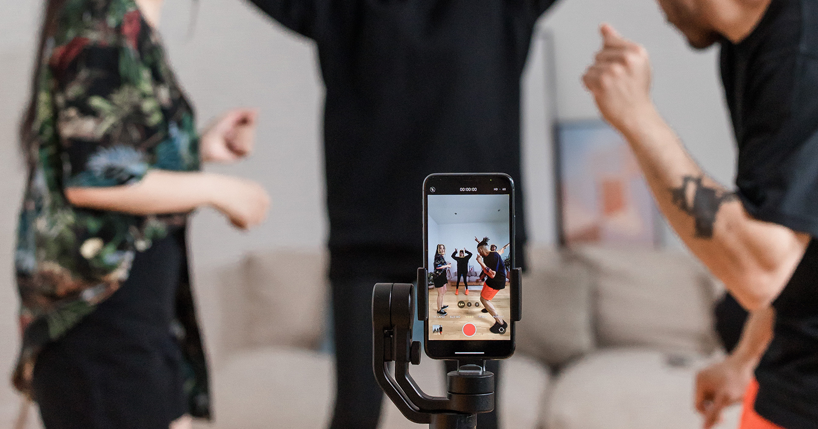 Mensen die de kracht van TikTok ervaren door een dansje op te nemen in hun woonkamer met hun smartphone op een statief. Illustratie van de creativiteit en impact van TikTok op sociale expressie.